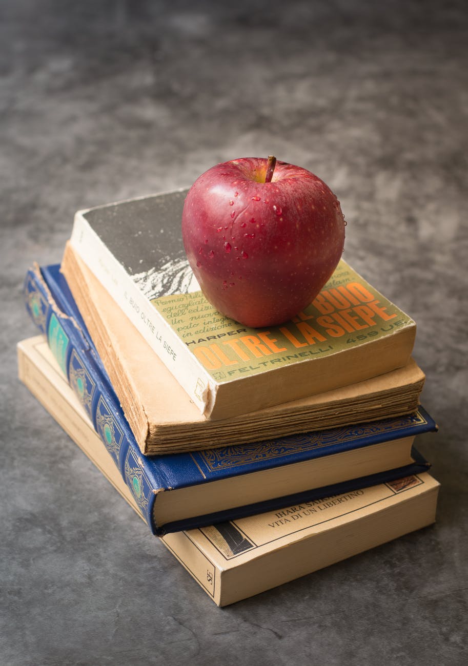 red apple on top of books
